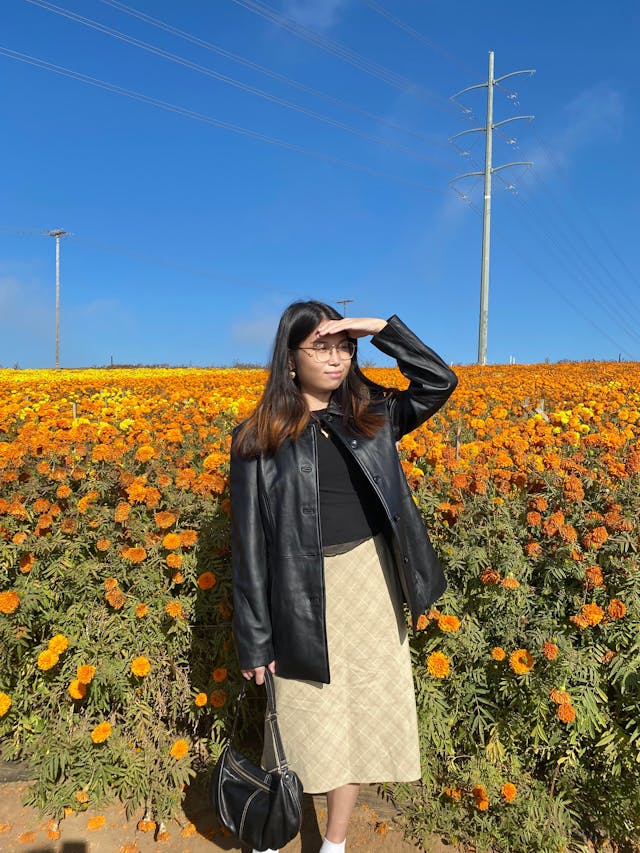Shelly Liu in front of an orange flowerfield